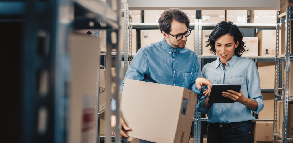 A man and a woman are talking in a storehouse.